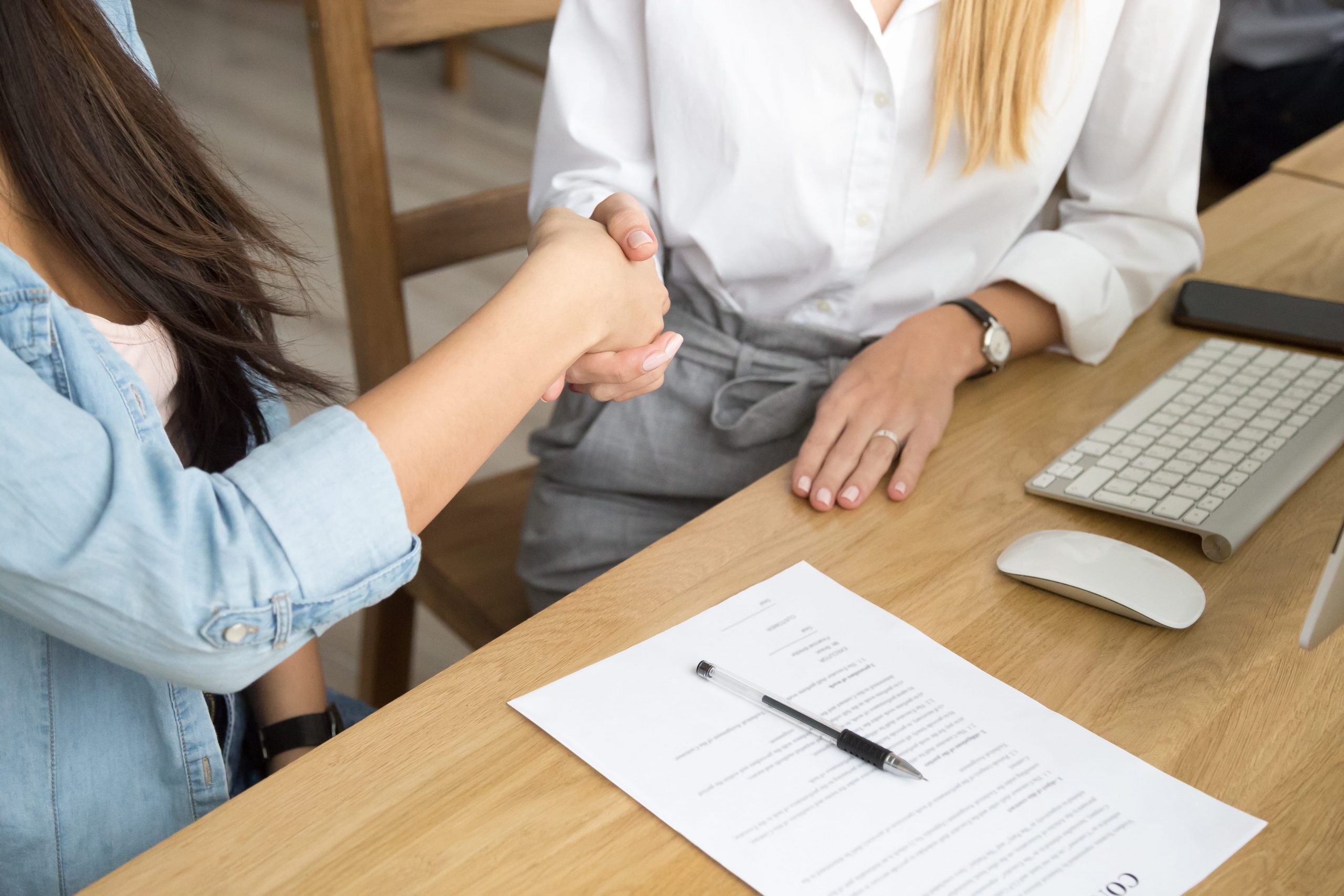 two-women-partners-handshaking-after-signing-business-contract-at-meeting-min two-women-partners-handshaking-after-signing-business-contract-at-meeting-min